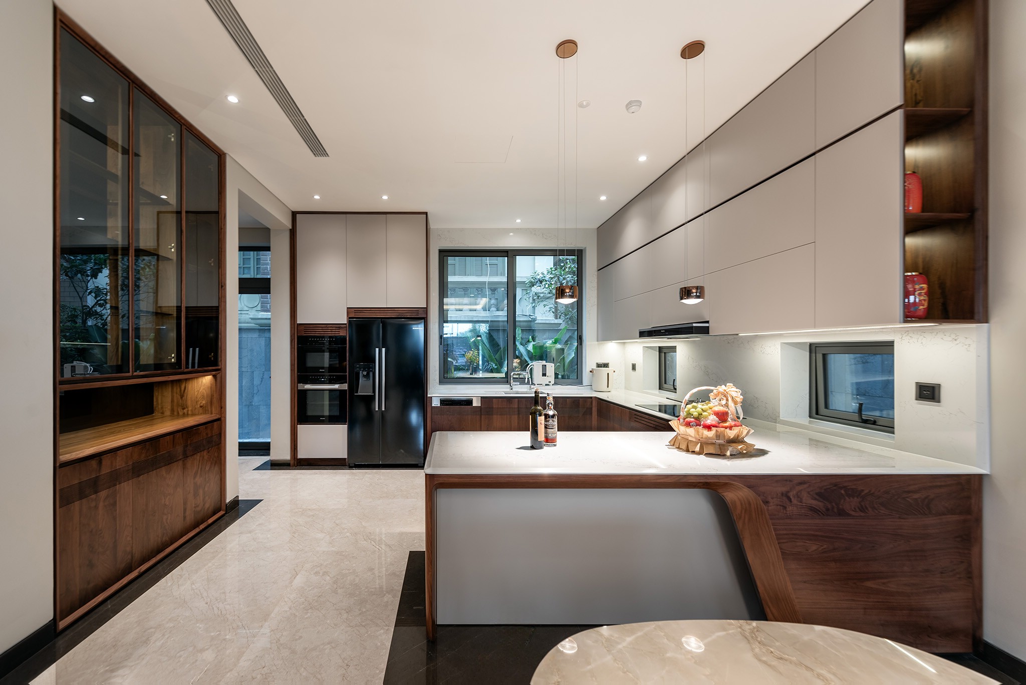 Mẫu tủ bếp hiện đại chữ L với bàn đảo liền khối và mặt đá marble trắng vân loang ghi